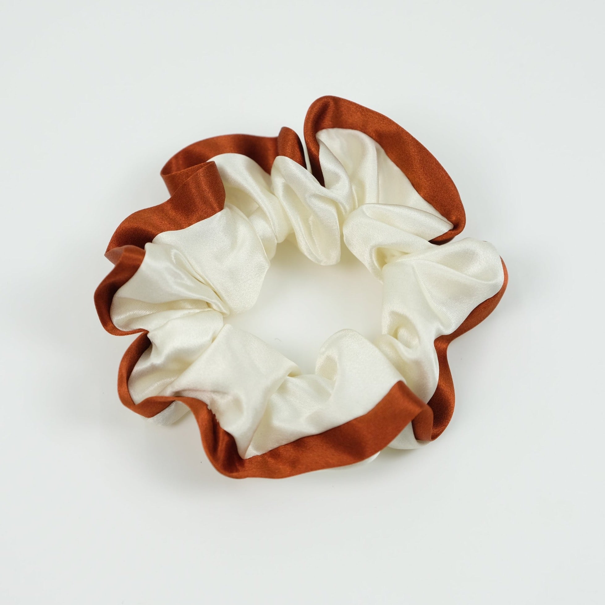a creamy white silk scrunchie with rust red edge