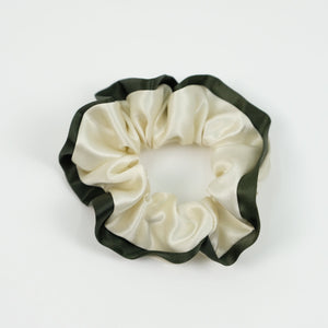 a creamy white silk scrunchie with dark green edge