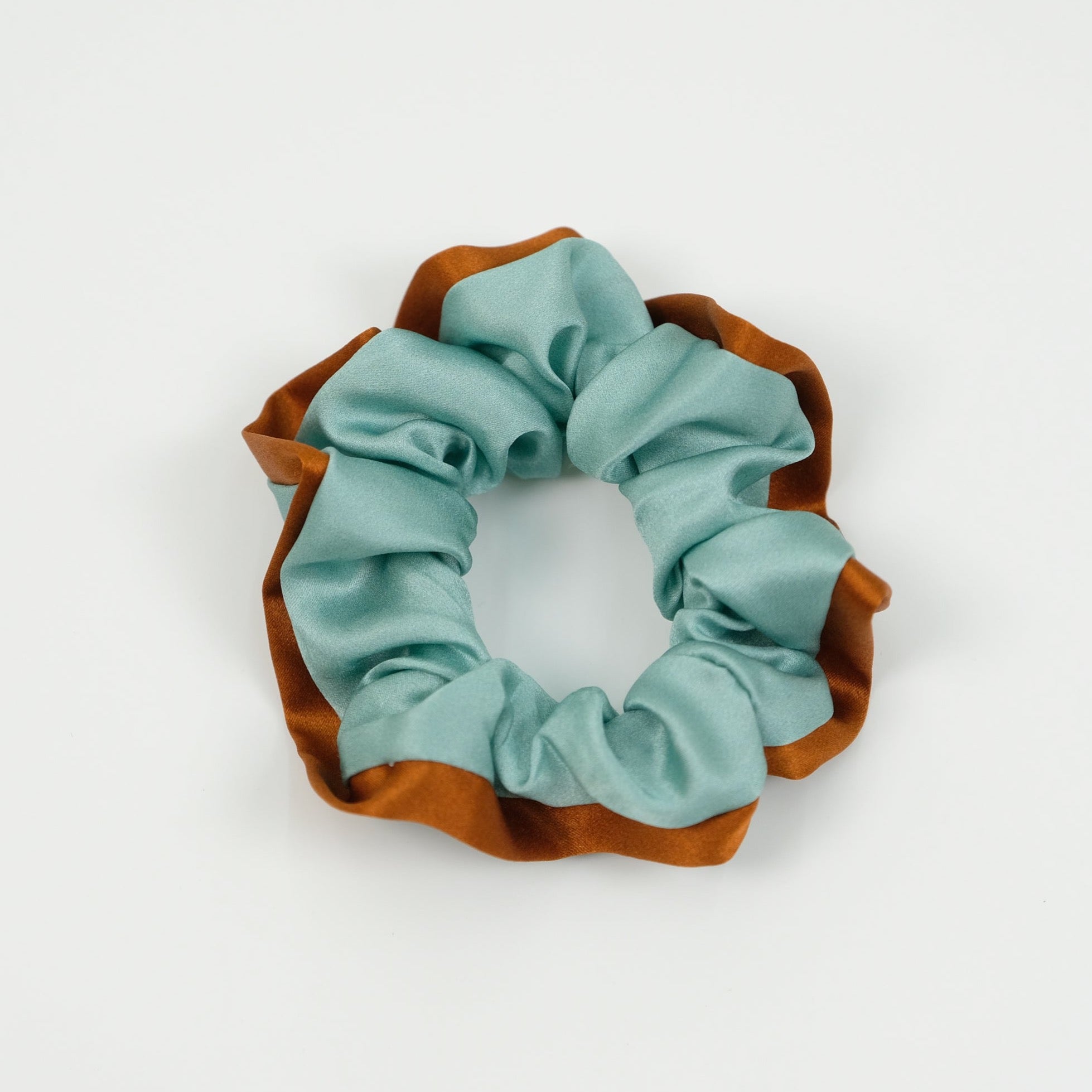 a mint blue silk scrunchie with burnt orange edge