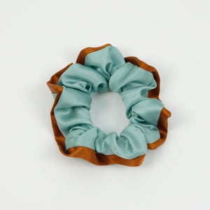 a mint blue silk scrunchie with burnt orange edge