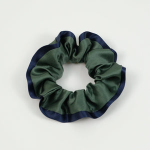 a green silk scrunchie with navy blue edge