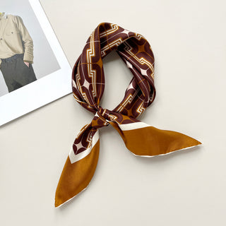 65x65cm brown silk bandana scarf with a geometric pattern and hand-rolled edges, featuring a contrasting border. Retro-inspired unisex accessory, perfect for versatile styling around the neck, hair, or as an accent piece.