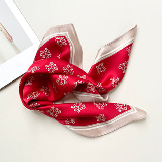 a red small silk scarf with beige edge featuring crown print