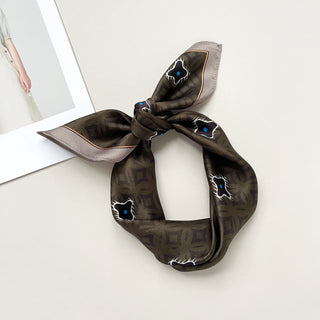 a dark olive green silk scarf neckerchief featuring timeless print, knotted as a headband