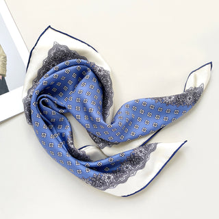 a cerulean blue square silk scarf with white base and navy blue hand-rolled hems, featuring boho style print