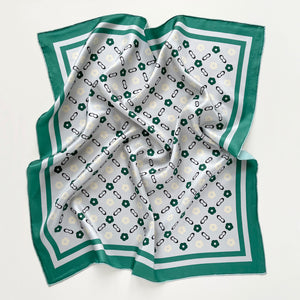 a turquoise square silk scarf with light grey base, featuring simplified floral print