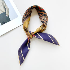 a vintage vibe boho chic square silk scarf with indigo base and hand-rolled hems, featuring retro charm floral print, knotted as a neckerchief 