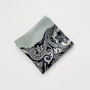 a pale pea green silk scarf with black boho style print, folded as a square