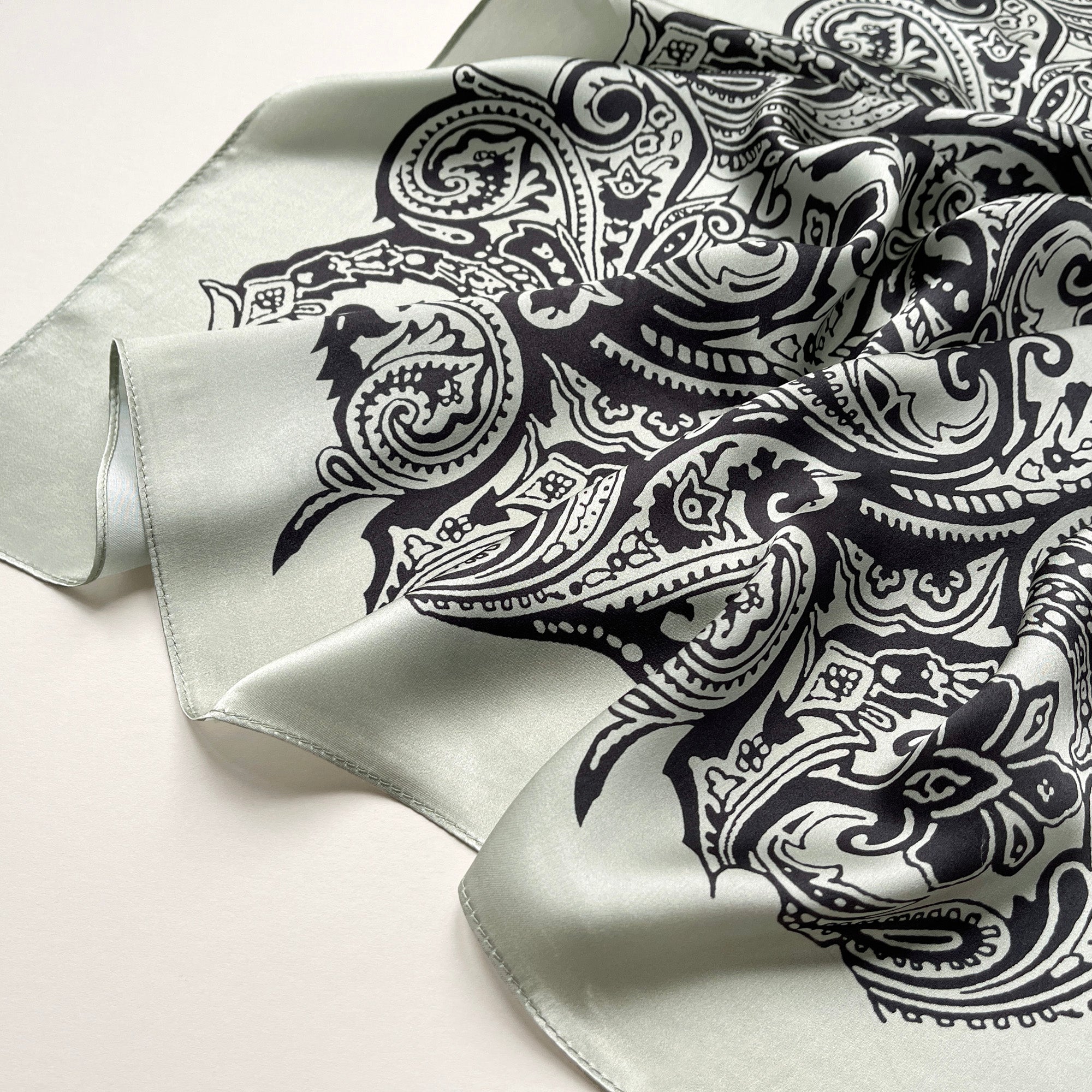 a pale pea green silk scarf with black boho style print