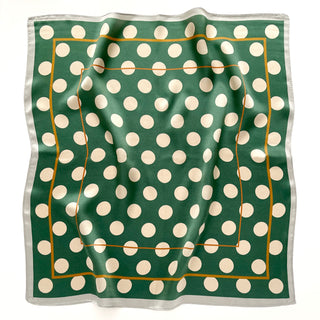 a jade green silk scarf bandana featuring light beige polka dot print and mustard yellow line near the edge