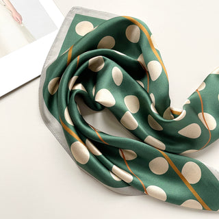 a jade green silk scarf bandana featuring light beige polka dot print and mustard yellow line near the edge