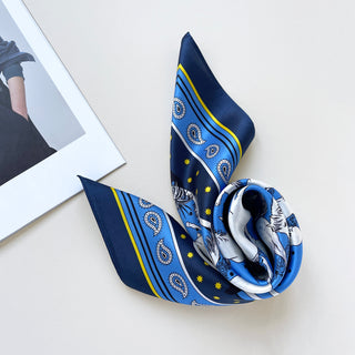 a bright blue men's silk scarf featuring classic horse riding and paisley prints with navy blue edge 