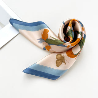 a small silk scarf in sky blue and orange featuring lily and butterfly prints 