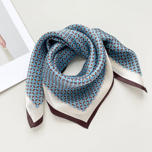 a small square silk scarf with brown edge featuring sky blue circle print