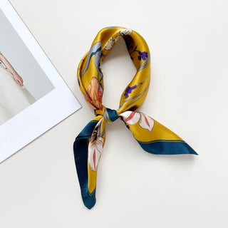 vintage vibe silk bandana scarf in vibrant mustard yellow featuring flowers and butterflies print with dark blue edge, knotted as a classic neckerchief 