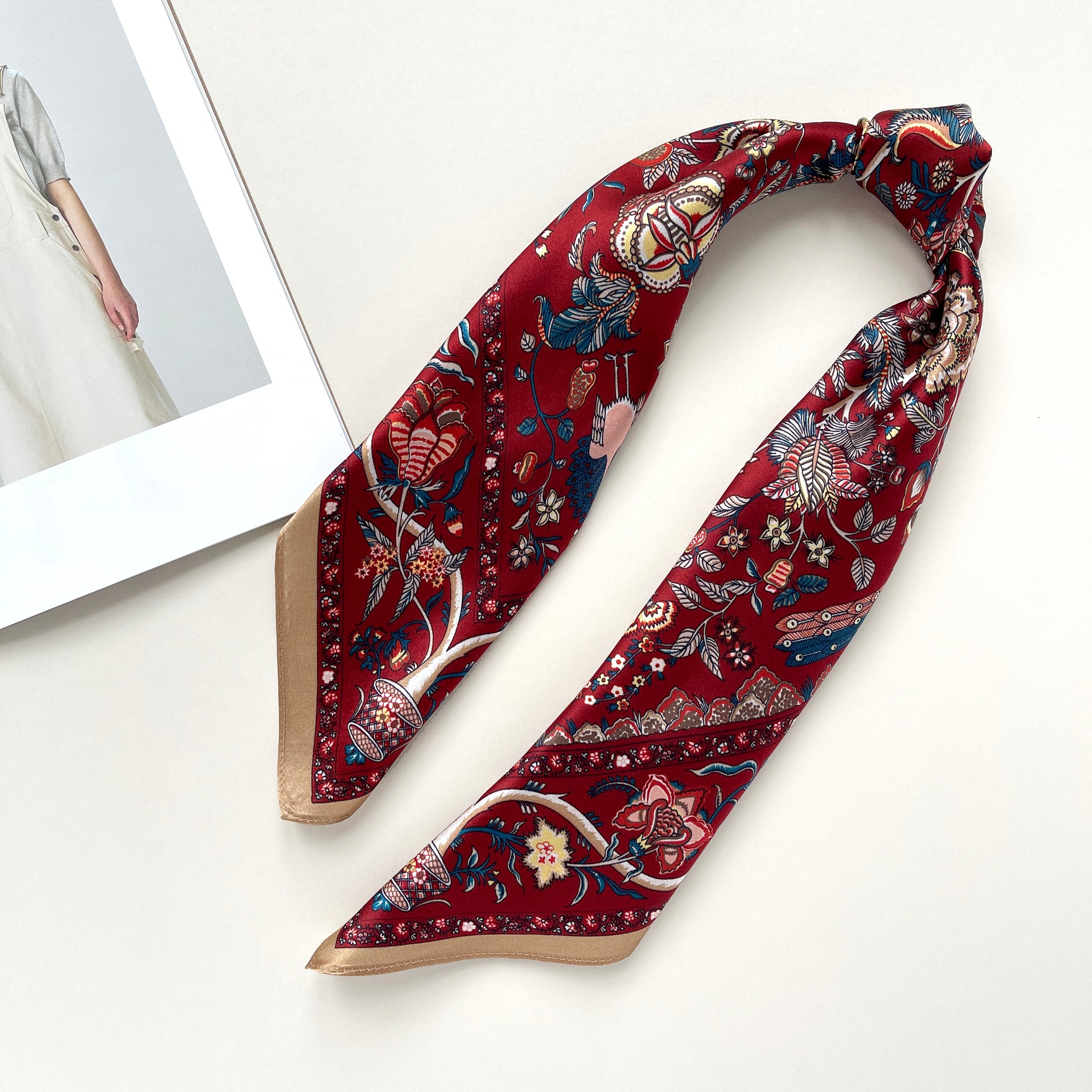 red vintage inspired floral silk scarf with beige edge knotted as a ponytail