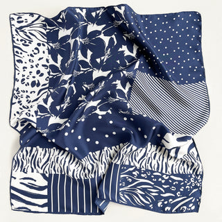 a navy blue and white square silk scarf featuring the combination of floral motifs, polka dots, and stripes prints with hand-rolled edges