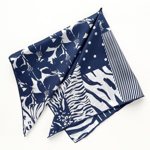 a white and blue square silk scarf featuring the combination of floral motifs, polka dots, and stripes prints with hand-rolled edges