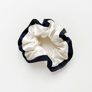 a cream white silk scrunchie with black edge
