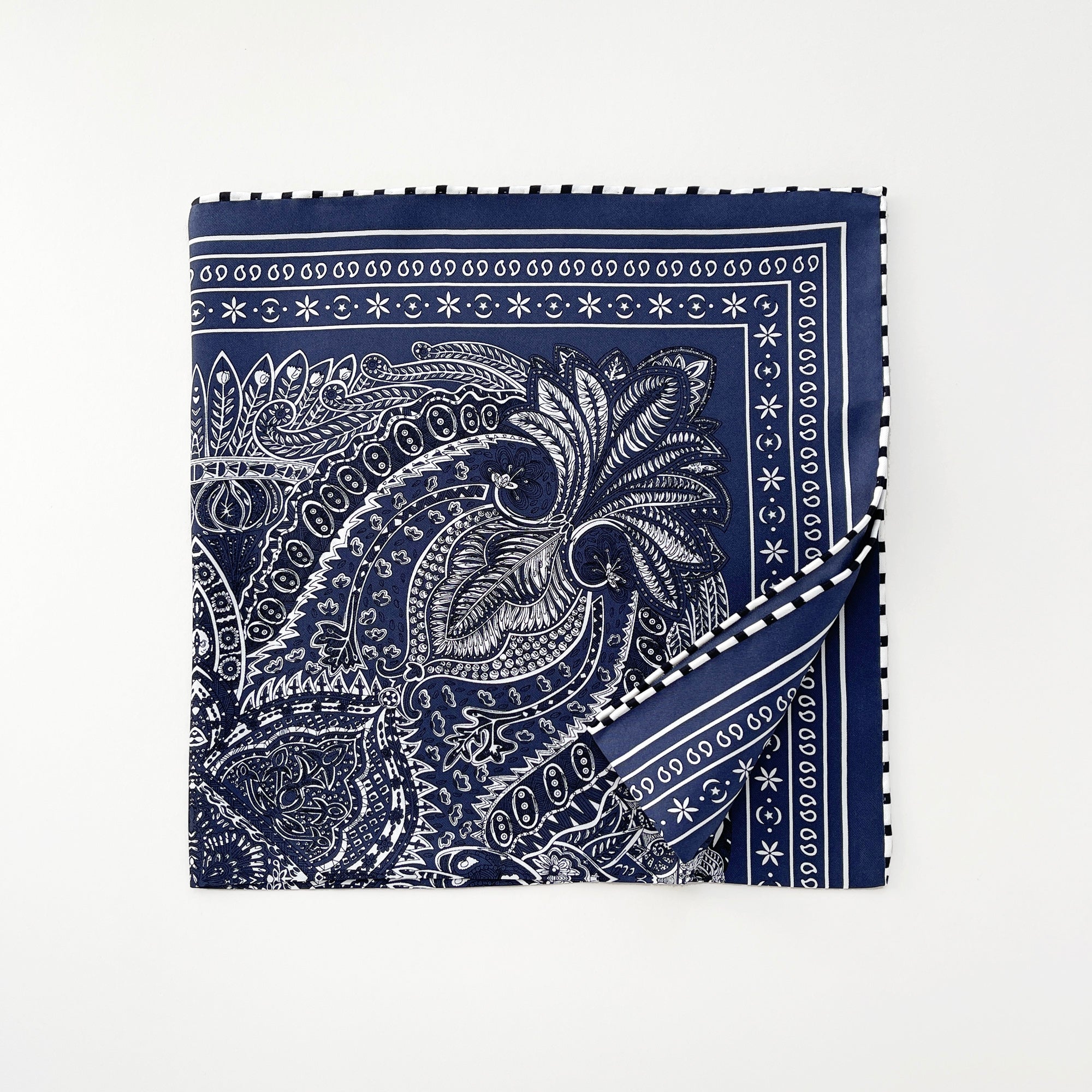 a navy blue bandana silk scarf featuring white and black symmetric pattern with striped hand-rolled edges