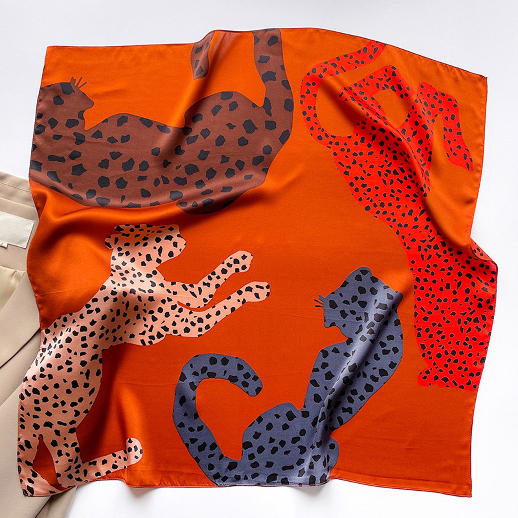 a women's leopard print square silk scarf bandana in orange, brown, black and pink hues