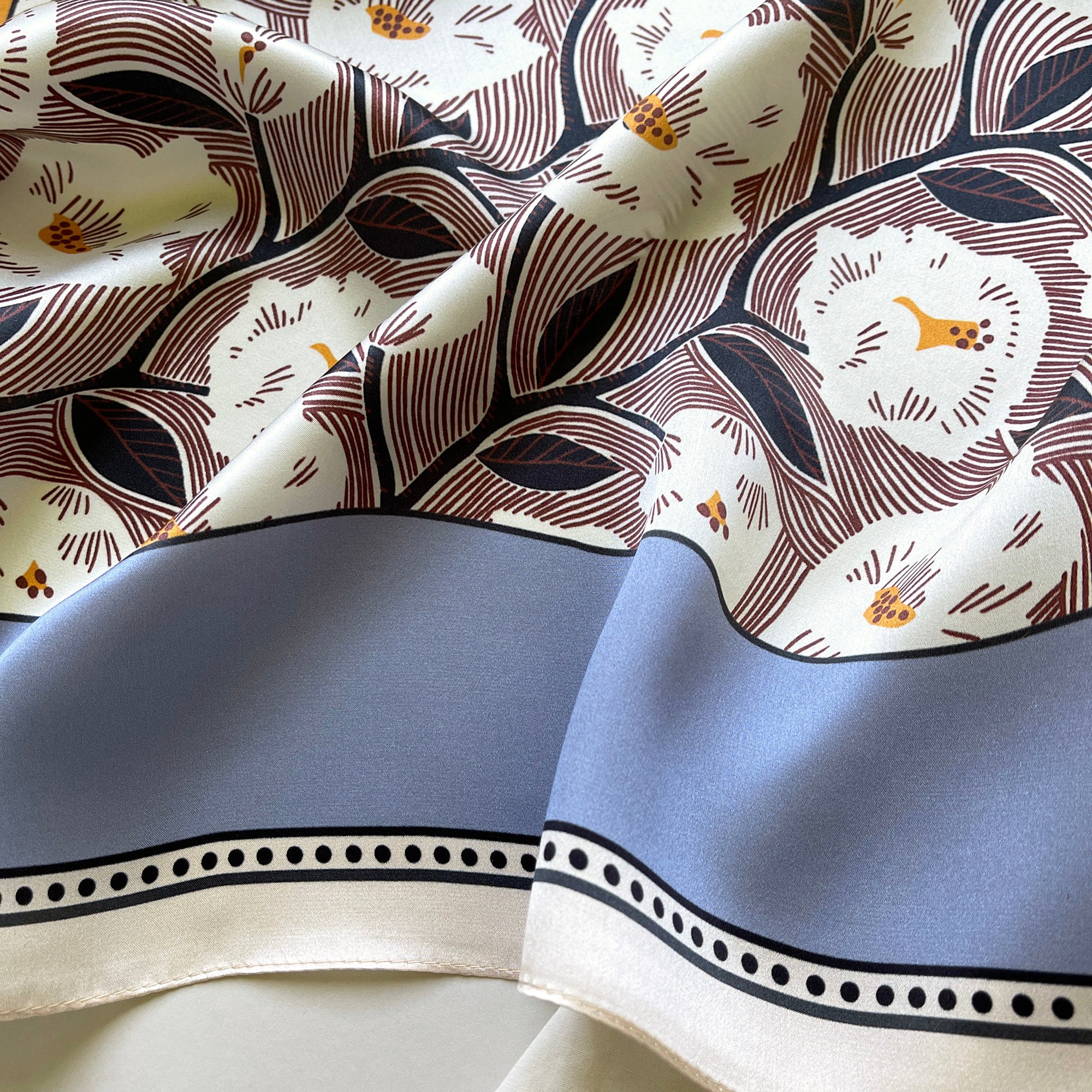 a women's silk scarf featuring white rock roses print with cornflower blue edge