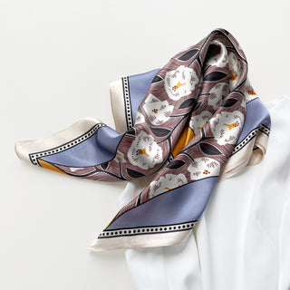 a women's silk scarf featuring white rock roses print with cornflower blue and orange edges, paired with a white dress