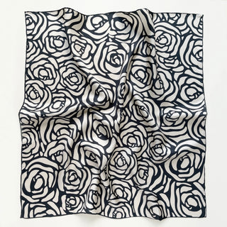 a white base women's silk square scarf with deep charcoal grey abstract rose print and hand-rolled edges