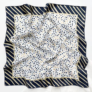 Timeless square silk scarf for men and women featuring a Dalmatian-inspired dot pattern in black and beige on a white background, with a black and beige striped border and hand-rolled edges