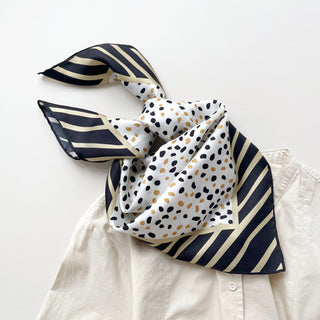 Timeless square silk scarf for men and women featuring a Dalmatian-inspired dot pattern in black and beige on a white background, with a black and beige striped border and hand-rolled edges