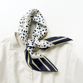 Timeless square silk scarf for men and women featuring a Dalmatian-inspired dot pattern in black and beige on a white background, with a black and beige striped border and hand-rolled edges