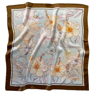 68x68 cm square silk scarf featuring a soft, light blue background with an intricate floral pattern of hibiscus flowers and butterflies. The flowers are outlined in shades of cream, yellow, and light brown, complemented by delicate leaves. The scarf has a wide, brown border framing the design.