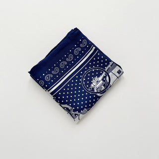 Navy blue silk bandana with vintage carriage and wheel print, featuring white polka dots and intricate hand-rolled hems. Unisex design made from 100% silk twill, perfect as a neckerchief or versatile accessory.