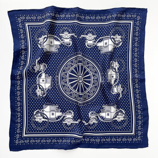 Navy blue silk bandana with vintage carriage and wheel print, featuring white polka dots and intricate hand-rolled hems. Unisex design made from 100% silk twill, perfect as a neckerchief or versatile accessory.