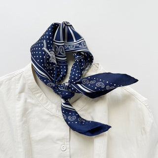 Navy blue silk bandana with vintage carriage and wheel print, featuring white polka dots and intricate hand-rolled hems. Unisex design made from 100% silk twill, perfect as a neckerchief or versatile accessory.