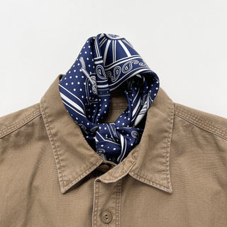 Navy blue silk bandana with vintage carriage and wheel print, featuring white polka dots and intricate hand-rolled hems. Unisex design made from 100% silk twill, perfect as a neckerchief or versatile accessory.