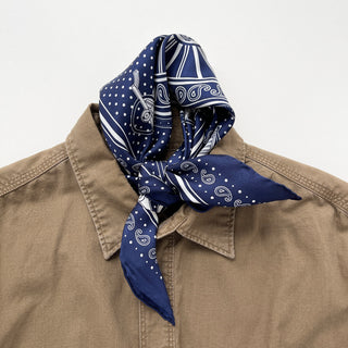 Navy blue silk bandana with vintage carriage and wheel print, featuring white polka dots and intricate hand-rolled hems. Unisex design made from 100% silk twill, perfect as a neckerchief or versatile accessory.