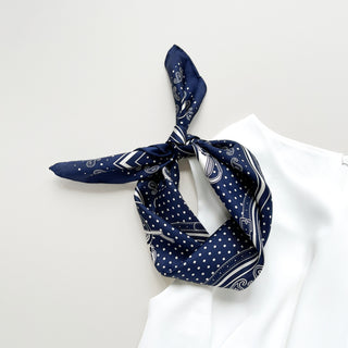 Navy blue silk bandana with vintage carriage and wheel print, featuring white polka dots and intricate hand-rolled hems. Unisex design made from 100% silk twill, perfect as a neckerchief or versatile accessory.