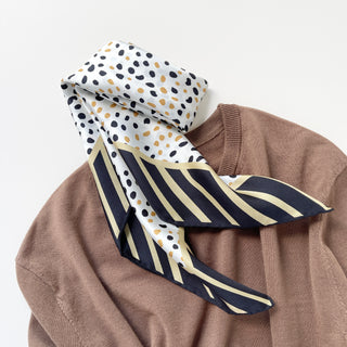 Timeless square silk scarf for men and women featuring a Dalmatian-inspired dot pattern in black and beige on a white background, with a black and beige striped border and hand-rolled edges