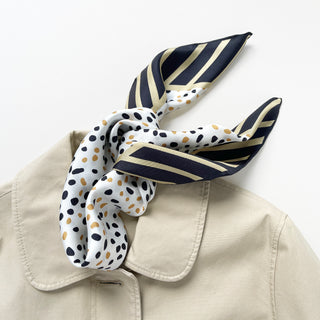 Timeless square silk scarf for men and women featuring a Dalmatian-inspired dot pattern in black and beige on a white background, with a black and beige striped border and hand-rolled edges