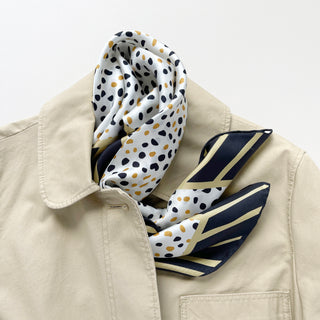 Timeless square silk scarf for men and women featuring a Dalmatian-inspired dot pattern in black and beige on a white background, with a black and beige striped border and hand-rolled edges