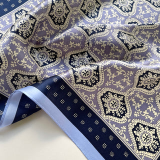 Unisex silk bandana scarf featuring a geometric floral pattern in velvet, navy, and white, with a navy border.