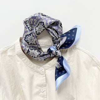 Unisex silk bandana scarf featuring a geometric floral pattern in velvet, navy, and white, with a navy border.