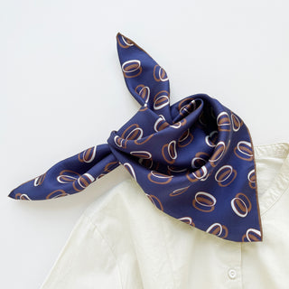 Indigo purple unisex silk bandana scarf with a circular pattern, made from 100% silk twill, featuring hand-rolled edges. The scarf measures 53x53cm and is designed for both men and women.