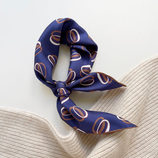 Indigo purple unisex bandana silk scarf with a circular pattern, made from 100% silk twill, featuring hand-rolled edges. The scarf measures 53x53cm and is designed for both men and women.