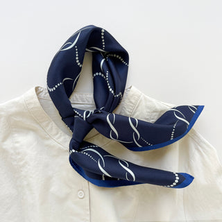 65x65 cm navy blue silk scarf with a geometric pattern and hand-rolled edges, designed for both men and women. The scarf features a smooth silk texture and is accented with elegant white wave-like lines, perfect for versatile styling.