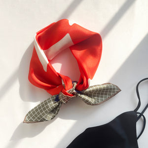 an orangey red geometric print silk scarf/bandana/neckerchief/square with hand rolled hems
