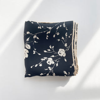 a folded black and white floral print small silk scarf with hand-rolled hems 