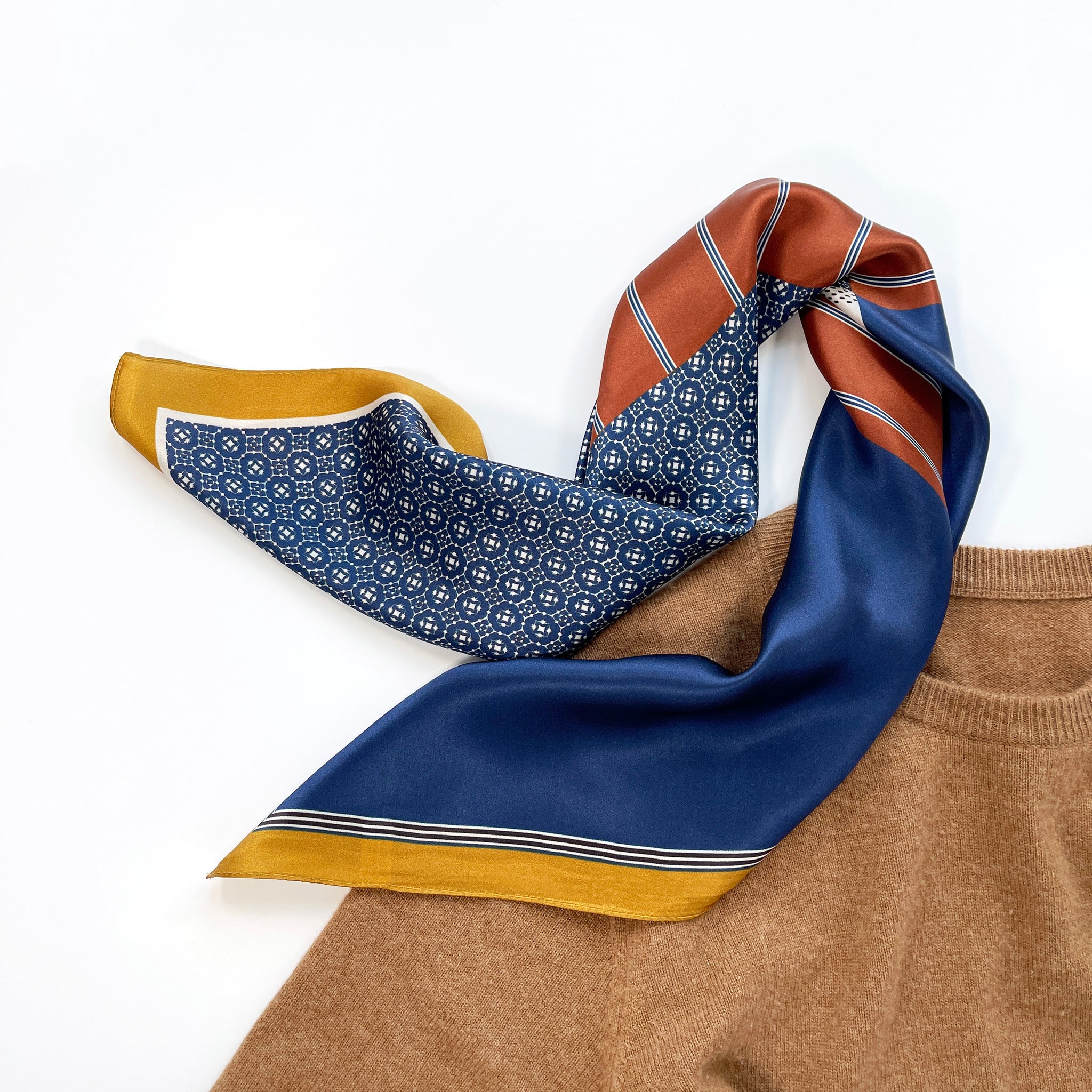 a mens silk scarf with geometric pattern in navy blue, copper and mustard yellow