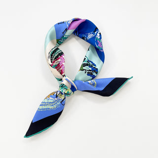 a vibrant small square silk scarf with snake print and hand-rolled hems knotted as a neckerchief